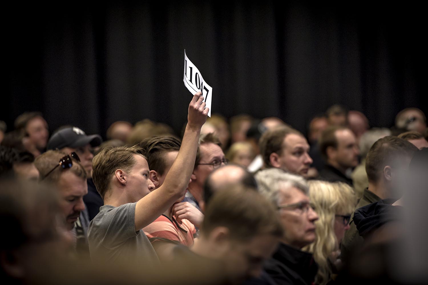 Auktion person håller upp ett papper
