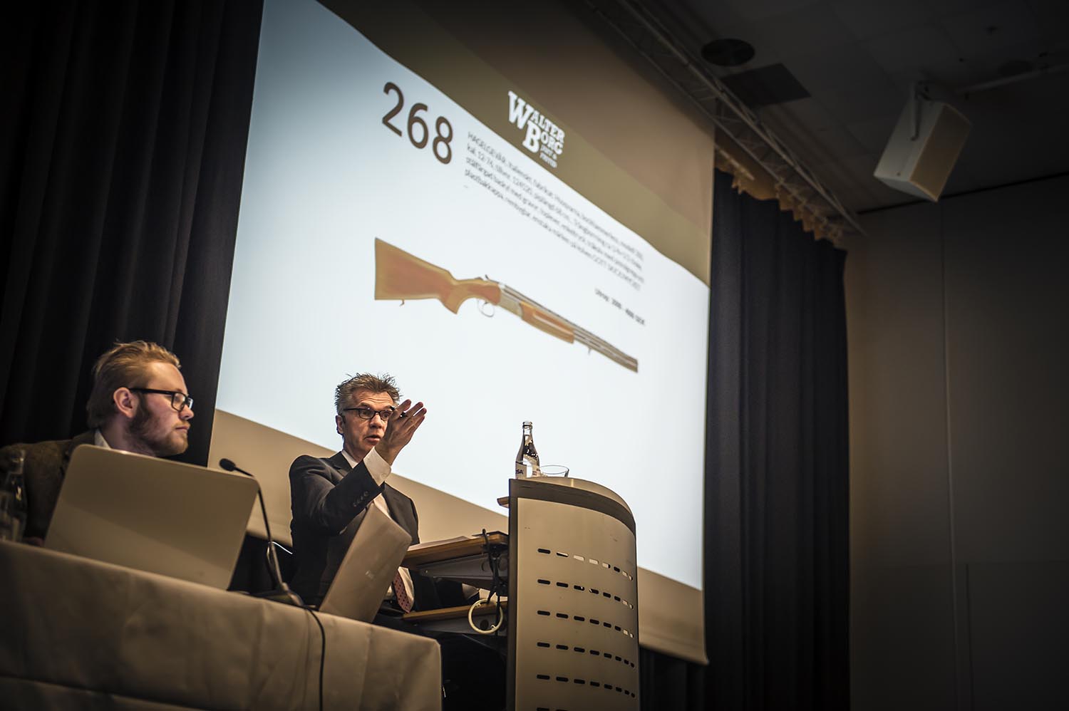 Auktion två personer visa bild på storskärm