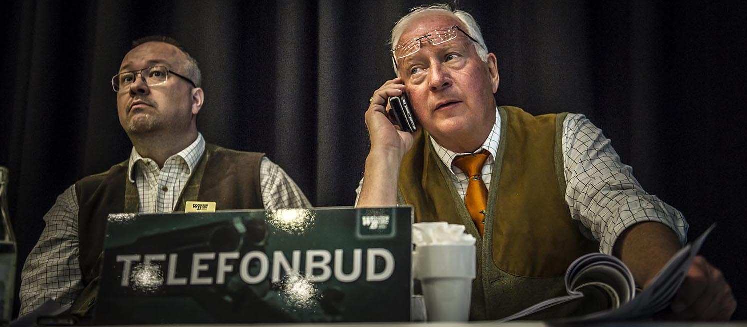 Två personer i en auktionssal